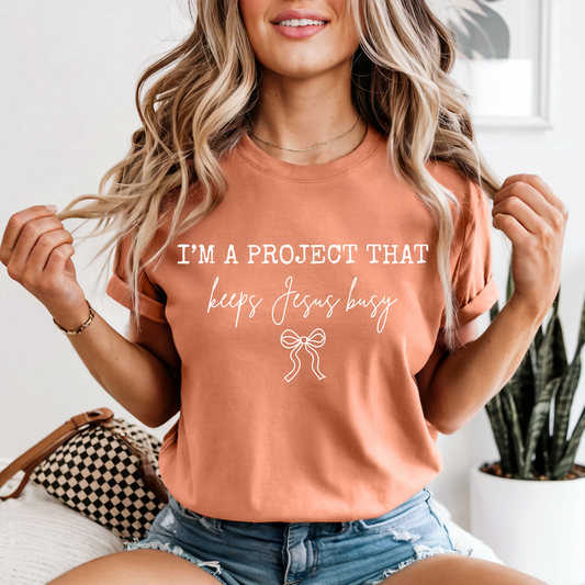 I’m A Project That Keeps Jesus Busy Graphic Tee | Funny Faith Shirt | Christian Humor Tee | Boutique T-Shirt
